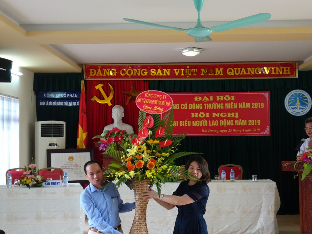 Bà Nguyễn Thị Hồng Loan - Phó Trưởng ban đầu tư 2 tặng hoa chúc mừng Đại hội